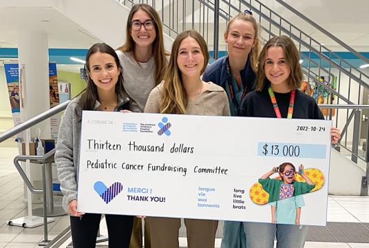students holding big donation cheque