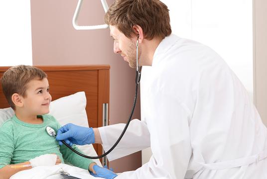 Un médecin écoute le coeur d'un enfant au moyen d'un stéthoscope